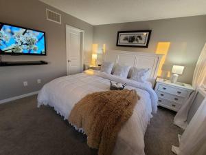 a bedroom with a large bed and a flat screen tv at Living the Dream with Inground Heated Pool, Hot Tub, & Beach in Cobourg