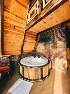 a bath tub in a room with a brick wall at DELLA SUİT BUNGALOW in Çamlıhemşin