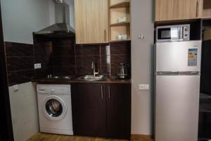 a kitchen with a refrigerator and a washing machine at Gudauri Club 2100 Apt206 in Gudauri