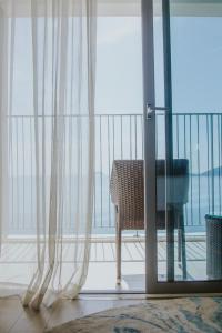a room with a glass door with a chair on a balcony at Holi Panorama Nha Trang in Nha Trang