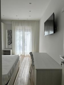 een slaapkamer met een bed, een bureau en een raam bij Bed and Breakfast Al Portanova in Reggio di Calabria
