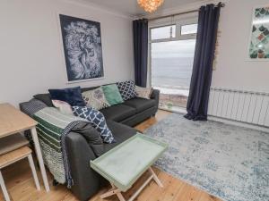 ein Wohnzimmer mit einem Sofa und einem Tisch in der Unterkunft Sea Snug in Berwick-Upon-Tweed