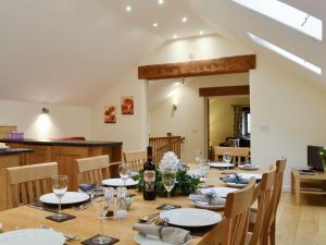uma sala de jantar com uma mesa com cadeiras e copos de vinho em Tythe Barn em Froggatt