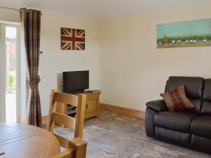 a living room with a couch and a television at The Old Dairy in Normanton on Trent