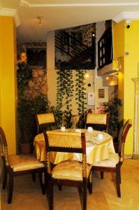 Colony Inn Hotel في أمباتو: طاولة طعام مع كراسي وجدار اصفر
