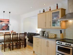 uma cozinha e sala de estar com mesa e cadeiras em Lia Fail em Ballachulish
