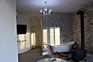 y baño con bañera blanca y pared de ladrillo. en Tower of the sun en Majdal Shams
