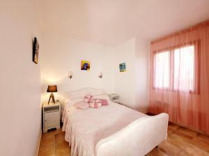 een slaapkamer met een bed met een roze strik erop bij Maison de 50 m2 a 400 m plage et piscine in Six-Fours-les-Plages