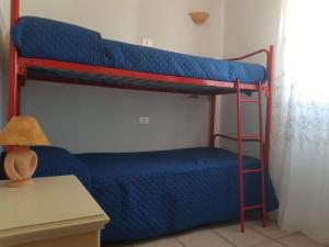 um quarto com 2 beliches e lençóis azuis em casa a pochi minuti dalla spiaggia di vignola em Vignola Mare