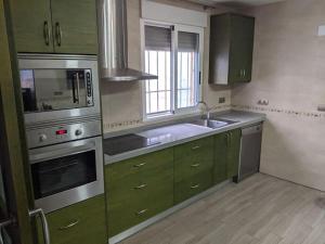 a kitchen with green cabinets and a sink at Casa de campo muy grande, con piscina y pistas in Fortuna
