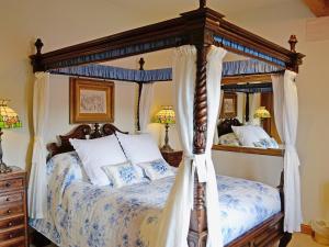 a bedroom with a four poster canopy bed at Baldash Lodge in Branscombe