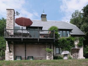 a house with a deck and an umbrella at Baldash Lodge in Branscombe