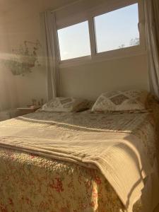 1 cama en un dormitorio con 2 ventanas en Apartamentob301 coliving bombinhas, en Bombinhas
