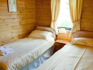 - une chambre avec des lits jumeaux et une fenêtre dans l'établissement Larch Cottage - S4428, à Kirkton of Glenisla