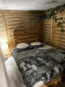 um quarto com uma cama e uma parede de madeira em Appartement 2 chambres em Brignoles