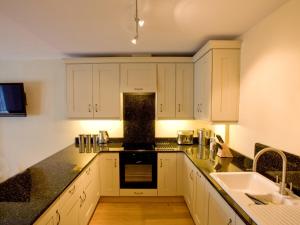 a kitchen with white cabinets and a black counter top at Carrigbaun in Braithwaite