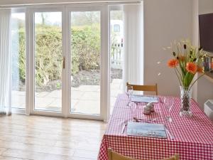 a dining room with a table and a glass door at Baytree Cottage 2 in Birch