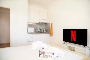 a living room with a tv and a kitchen at Sunny Suite Nordic - Lugano City -By EasyLife Swiss in Lugano