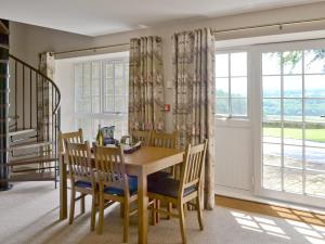 a dining room with a table and chairs and a window at Plover Cottage in Sharperton