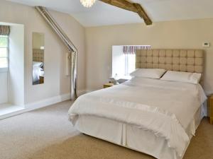 a bedroom with a large white bed and a window at Plover Cottage in Sharperton