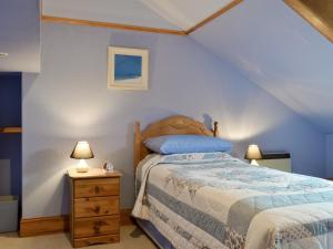 a bedroom with a bed and two lamps on a night stand at Loch Alsh Cottage - Uvo in Balmacara