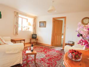 a living room with a couch and a table at Hay Cottage in Hoarwithy