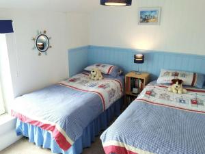Wren Cottage في Longhorsley: سريرين في غرفة نوم وعليهم دببة