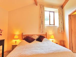 a bedroom with a bed with two pillows on it at Hay Cottage in Hoarwithy