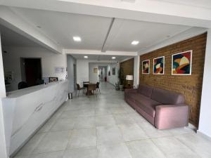 vestíbulo con sofá y pared de ladrillo en Alto da Serra Hotel, en Araruna