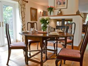a dining room with a wooden table and chairs at Grooms Cottage in Westleigh