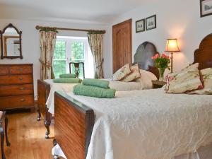 a bedroom with two beds and a dresser at Grooms Cottage in Westleigh