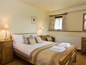 a bedroom with a large bed with towels on it at Stable Cottage - Ifu in Airton