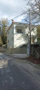 una casa blanca con una valla al lado de una calle en Villa Eva 2, 