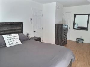 a bedroom with a bed and a mirror and a dresser at Chalet chez Antoine in Saint-Donat-de-Montcalm