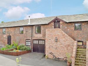 a brick house with a garage and a staircase at The Old Stables in Helsby