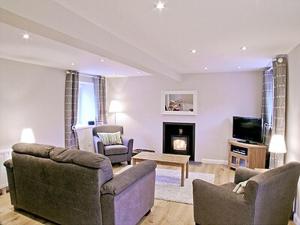 a living room with two couches and a fireplace at Blackmill Cottage in Taynuilt