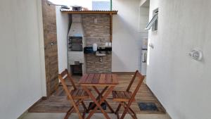 Habitación con 2 sillas, mesa y cocina. en Casa praia do Francês, en Marechal Deodoro