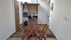 a room with two chairs and a table and a kitchen at Casa praia do Francês in Marechal Deodoro