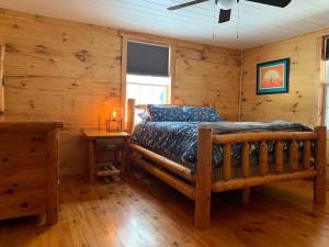 a bedroom with a bed in a log cabin at Cozy Creekside Cabin in the heart of Hocking Hills in Laurelville