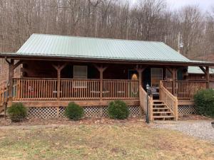 a large wooden cabin with a green roof at Cozy Creekside Cabin in the heart of Hocking Hills in Laurelville