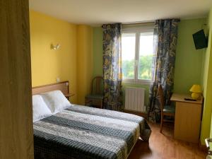 a small bedroom with a bed and a window at Hotel Colombié in Gorses