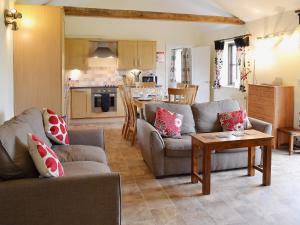 een woonkamer met 2 banken en een tafel bij The Cart Shed in High Halstow