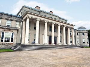 a large white building with columns on the front at Brooklyn Barn in Rolleston