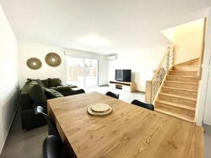 uma sala de estar com uma mesa de madeira e um sofá em Villa 8 personnes bord de mer climatisée em Saintes-Maries-de-la-Mer