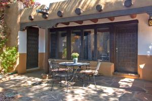 a patio with a table and chairs in front of a building at Las Brisas de Santa fe in Santa Fe