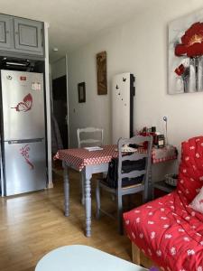 Pokój z kuchnią ze stołem i lodówką w obiekcie Beau studio plus, refait à neuf, tout confort, classé 3 étoiles par le comité départemantal du tourisme de la Haute Garonne w mieście Luchon