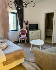 a bedroom with a bed and a table and a chair at Opera apartments in Tivat