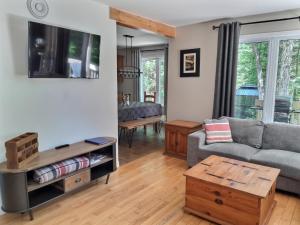 a living room with a couch and a table at Chalet chez Antoine in Saint-Donat-de-Montcalm
