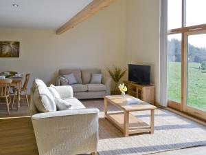 a living room with a couch and a table at Kingfisher Lodge in Hainford
