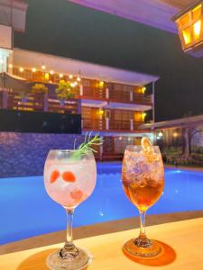 dos cócteles sentados en una mesa junto a una piscina en Esperanza Hotel - Oxapampa en Oxapampa